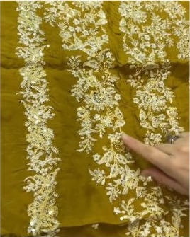 Gold thread embroidery on mustard fabric
